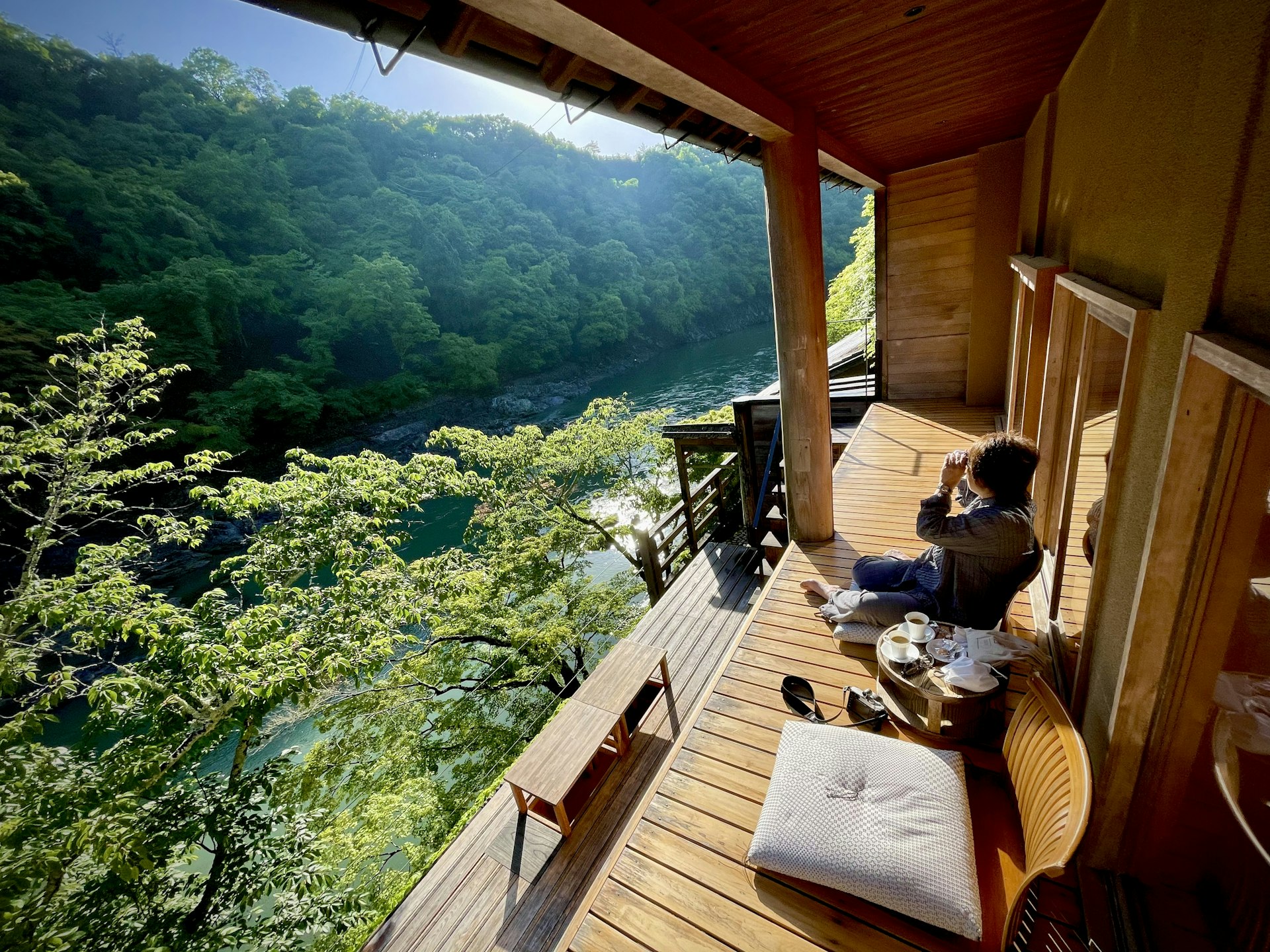 Couple enjoying morning coffee on private villa terrace with forest view