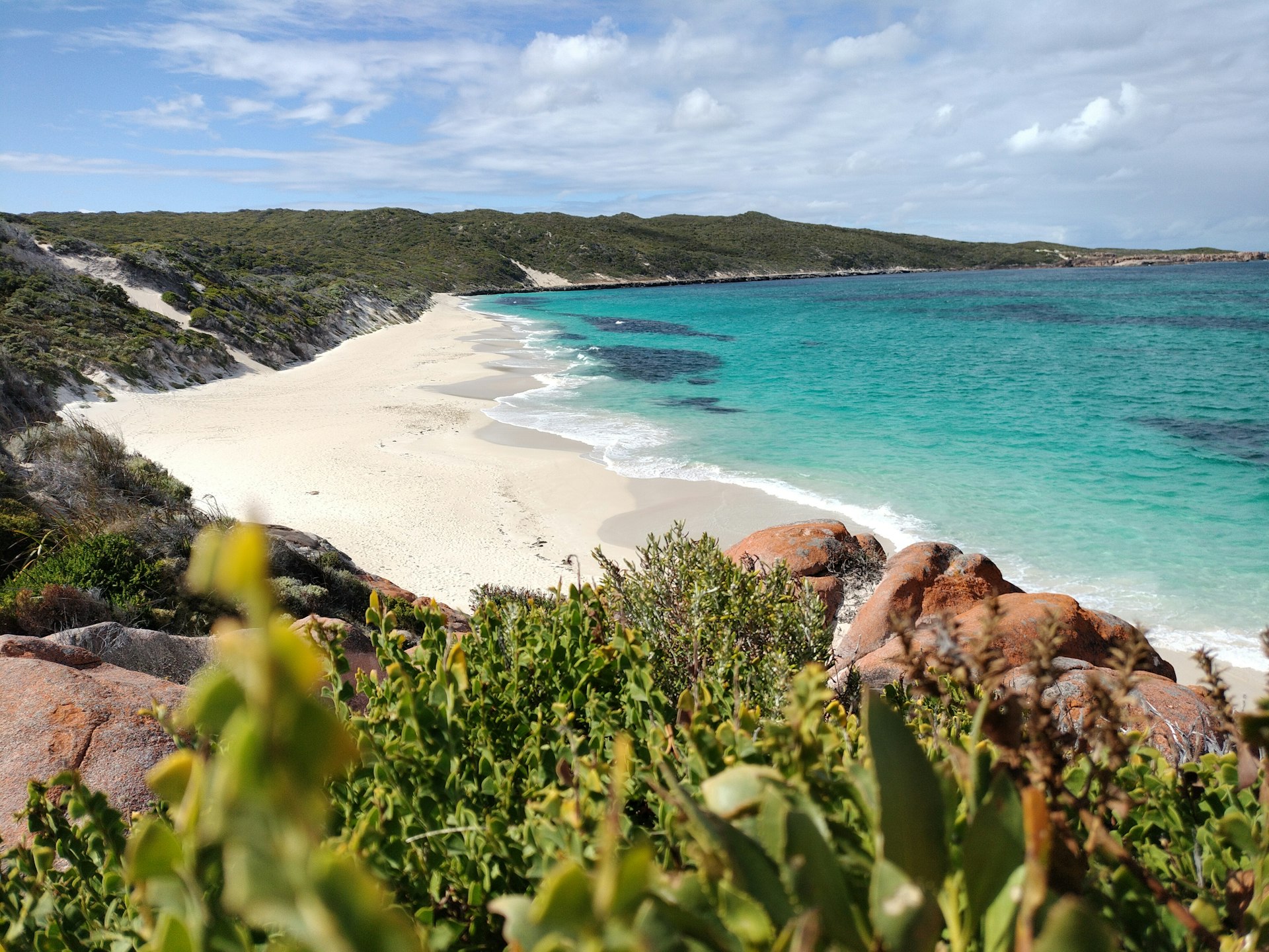 Pristine coastal landscape with turquoise water and lush green hills